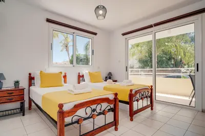 two beds in a room with a window at Apartment Helena in Ayia Napa