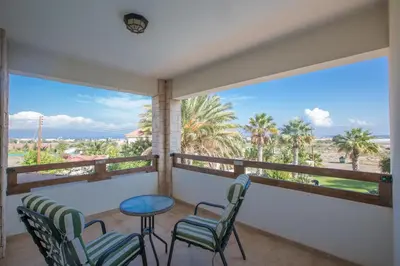 a balcony with chairs and a table and a view of the ocean at Protaras Holiday Villa Jo78 in Paralimni