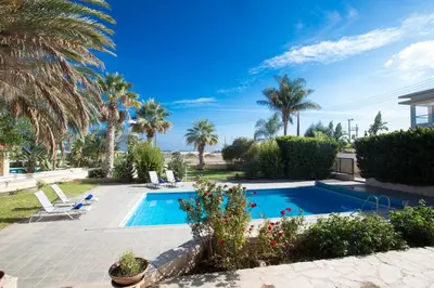 a swimming pool in a yard with palm trees at Protaras Holiday Villa Jo78 in Paralimni