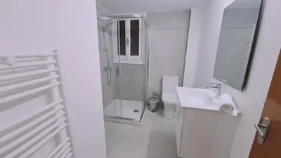 a white bathroom with a shower and a sink at STAY Mythos Down Town House in Nicosia