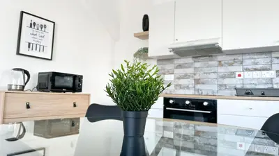 a kitchen with a black vase with a plant on a counter at Vacation mode Apartment in Ayia Napa