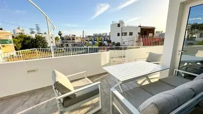 a balcony with a table and chairs on a roof at Vacation mode Apartment in Ayia Napa