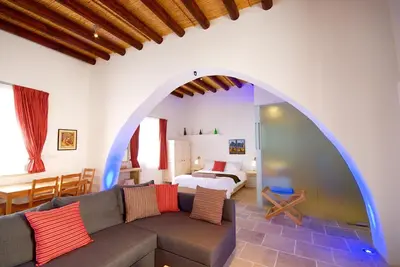 a living room with a couch and a bedroom at Palatakia - Adults Only in Kato Drys