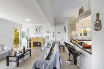 a living room with couches and a kitchen at Protaras Fig Tree Bay Sea View Villa , Jacuzzi Available April to October in Protaras