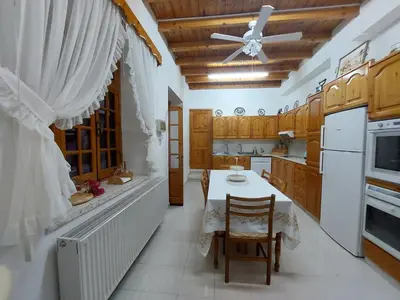 a kitchen with a table and a ceiling fan at Bougainvillea House Lefkara in Pano Lefkara