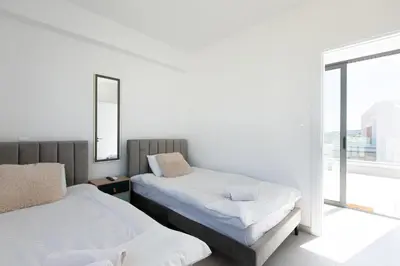two beds in a room with a window at Nelia Panorama Villa in Protaras