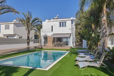 a villa with a swimming pool in front of a house at Sunrise Villa 9 in Ayia Napa