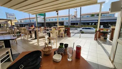 a restaurant patio with tables and chairs and a building at Ayia Napa Cyprus in Paralimni