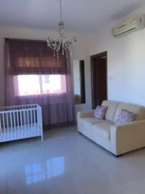 a living room with a couch and a crib at Villa 28 Protaras in Protaras