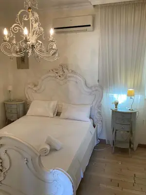 a bedroom with a large white bed and a chandelier at Anna Villa in Protaras