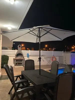 a table with an umbrella on a patio at night at Anna Villa in Protaras