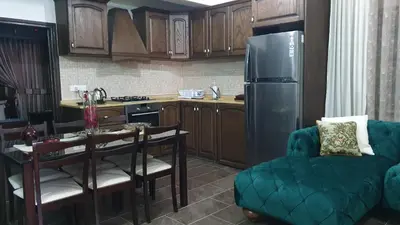 a kitchen with a couch and a table and a refrigerator at Oikos Selinolithos in Alaminos