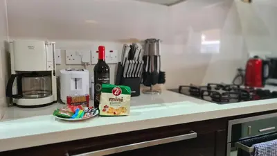 a kitchen counter with a bottle of wine and a plate at STAY Serenity Apartment in Yukarı Lakatamya