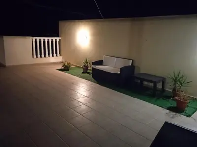 a patio at night with a couch and potted plants at Xylophagou Rest and Relax 2 Ayia Napa Larnaca 1 bedroom apartment in Xylophaghou