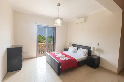 a bedroom with a bed with a red blanket at Protaras Holiday Villa Pa7 Private 7 Bedroom villa in Protaras