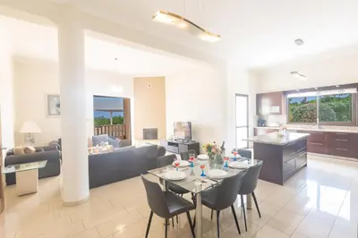 a kitchen and living room with a table and chairs at Protaras Holiday Villa Pa7 Private 7 Bedroom villa in Protaras