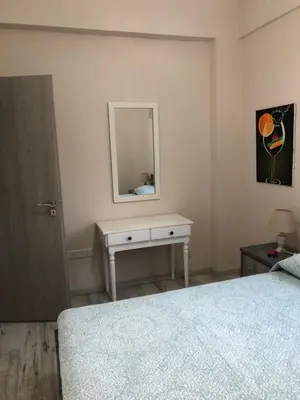 a bedroom with a bed and a table with a mirror at Great Views Apartment II in Limassol