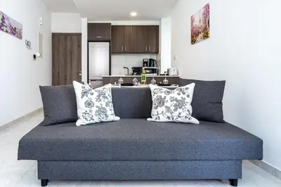 a blue couch with pillows in a living room at Lana 1-Bedroom Apt in Larnaca in Larnaka