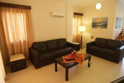 a living room with a couch and a table at A three-bedroom villa with a private pool and landscaped garden Wi-Fi in Pissouri