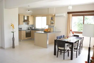a kitchen and dining room with a table and chairs at A three-bedroom villa with a private pool and landscaped garden Wi-Fi in Pissouri