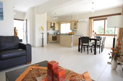 a living room and kitchen with a couch and a table at A three-bedroom villa with a private pool and landscaped garden Wi-Fi in Pissouri