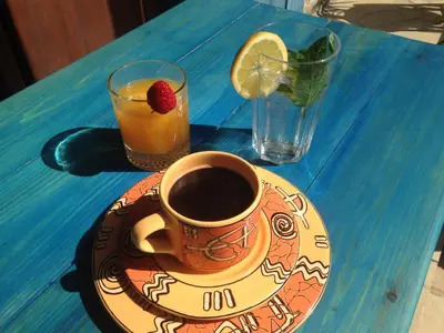 a cup of coffee and a drink on a blue table at Guesthouse Gonia in Pera Orinis