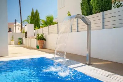 a water fountain in a swimming pool at Geo Panoramic Villa Konnos - Pool, Game Room, Gym in Protaras