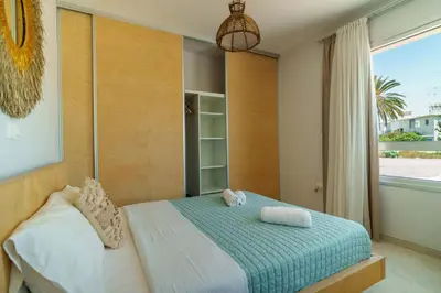 a bedroom with a bed and a large window at Geo Panoramic Villa Konnos - Pool, Game Room, Gym in Protaras