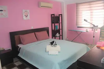 a pink bedroom with a bed with a toy dog on it at Marina Court Holiday Flat in Larnaka