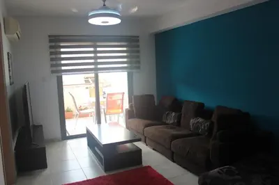a living room with a couch and a table at Marina Court Holiday Flat in Larnaka