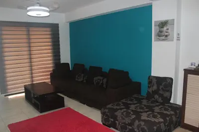 a living room with a couch and a chair at Marina Court Holiday Flat in Larnaka