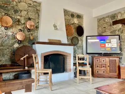 a living room with a fireplace and a flat screen tv at Traditional House with Mountain View - Dierona Village in Dierona