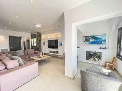 a living room with a couch and a fireplace at Erato Seafront Luxury Villa in Protaras