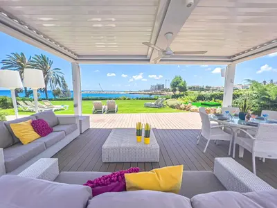 a patio with a couch and chairs and a table at Erato Seafront Luxury Villa in Protaras