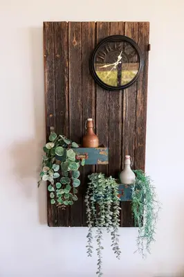 a clock on a wooden wall with a plant at Stella's Country House in Prodromos