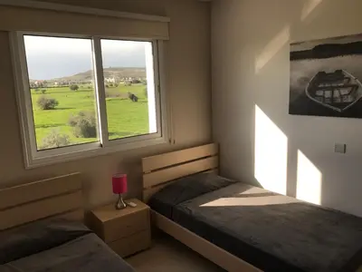 a bedroom with two twin beds and a window at Oceania Bay Penthouse in Pyla