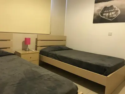 a bedroom with two beds and a picture on the wall at Oceania Bay Penthouse in Pyla