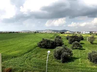 a green field with bushes and a street light at Oceania Bay Penthouse in Pyla