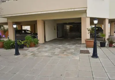 a building with a parking lot with a car at Elysso Apartments in Larnaka