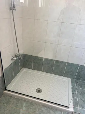 a shower stall with a shower door with a shower drain at Chara Cynthiana Villa in Paralimni