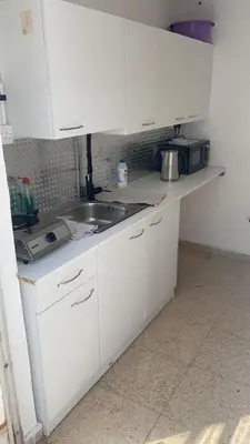 a kitchen with white cabinets and a sink at Unique City Hostel 100 meters from Beach in Larnaka