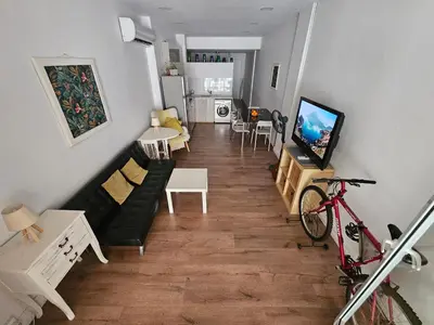 a living room with a black couch and a tv at Unique Sea & City Lifestyle Studio in Limassol