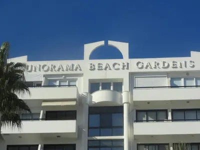 a white building with the words dominicanana beach gardens on it at Sunorama Beach Apartment in Larnaka