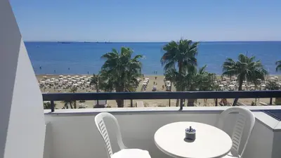 a balcony with a table and chairs and a view of the beach at Sunorama Beach Apartment in Larnaka