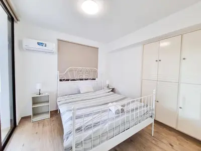 a white bedroom with a white bed and white cabinets at Home Sweet Home Apartment in Larnaka