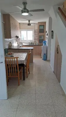 a kitchen with a table and chairs and a kitchen with a unintention at Comfortable 2BR Seaside House & Free Parking in Larnaka
