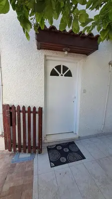 a white door on a building with a fence at Comfortable 2BR Seaside House & Free Parking in Larnaka