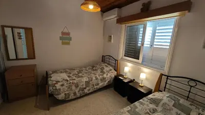 a small bedroom with two beds and a window at Comfortable 2BR Seaside House & Free Parking in Larnaka