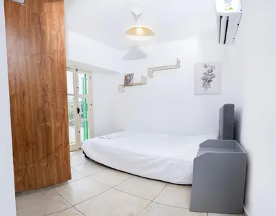 a white bedroom with a bed and a staircase at Private room in shared flat in Nicosia