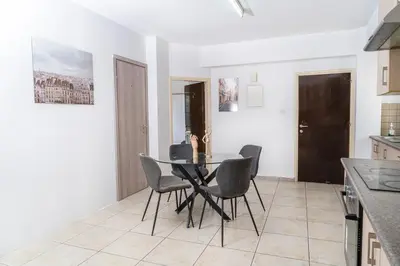 a dining room with a black table and chairs at Private room in shared flat in Nicosia